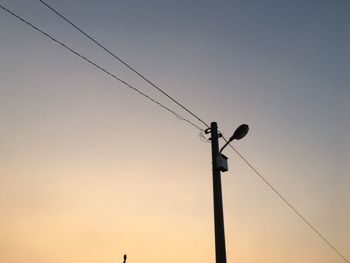 Low angle view of silhouette cables against clear sky