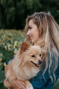 Young woman with dog standing outdoors