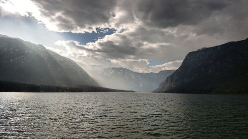 Scenic view of lake by mountains against sky