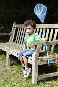 Boy on bench holding net