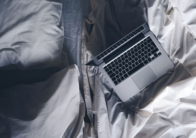 High angle view of man using laptop on bed