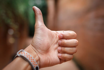 Close-up of man hand pose with finger thumb up