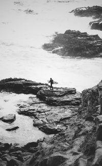 Man standing on rock at beach