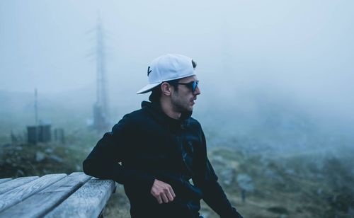 Young man looking away in foggy weather