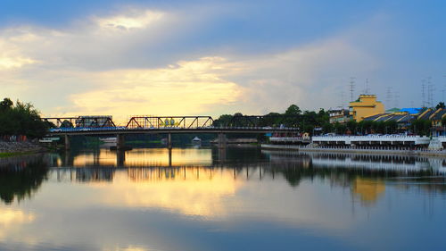 Bridge over river against sky in city