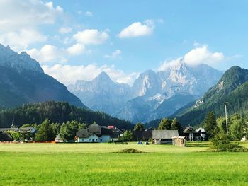 Houses on field by mountains against sky