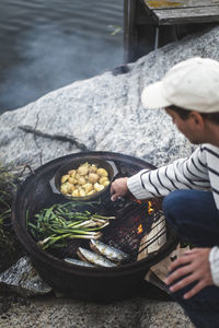 Mid adult man preparing food on barbecue grill at island