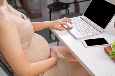 Midsection of woman using mobile phone