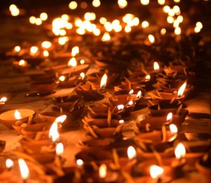 Close-up of burning diyas on floor