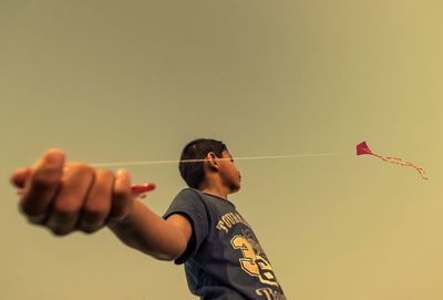 Rear view of man photographing against sky