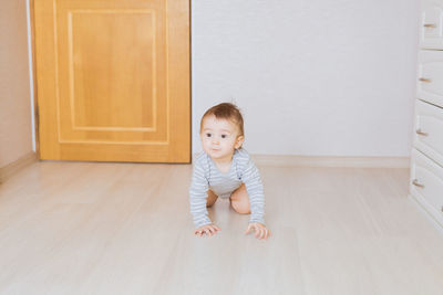 Portrait of cute baby girl on wooden floor