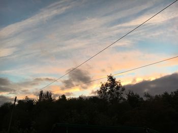 Silhouette of trees against cloudy sky