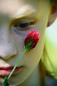 Close-up of girl with red flower