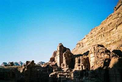 Low angle view of rock formation against clear blue sky