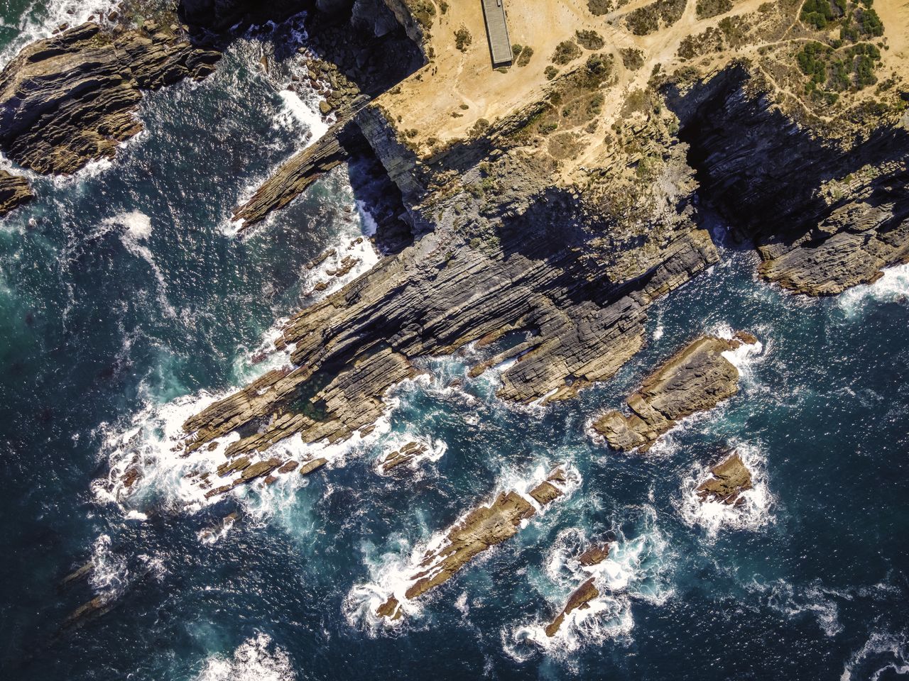 HIGH ANGLE VIEW OF ROCKS IN SEA