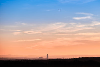 Silhouette bird flying against sky during sunset