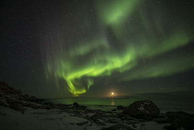 Scenic view of sea against aurora polaris at night