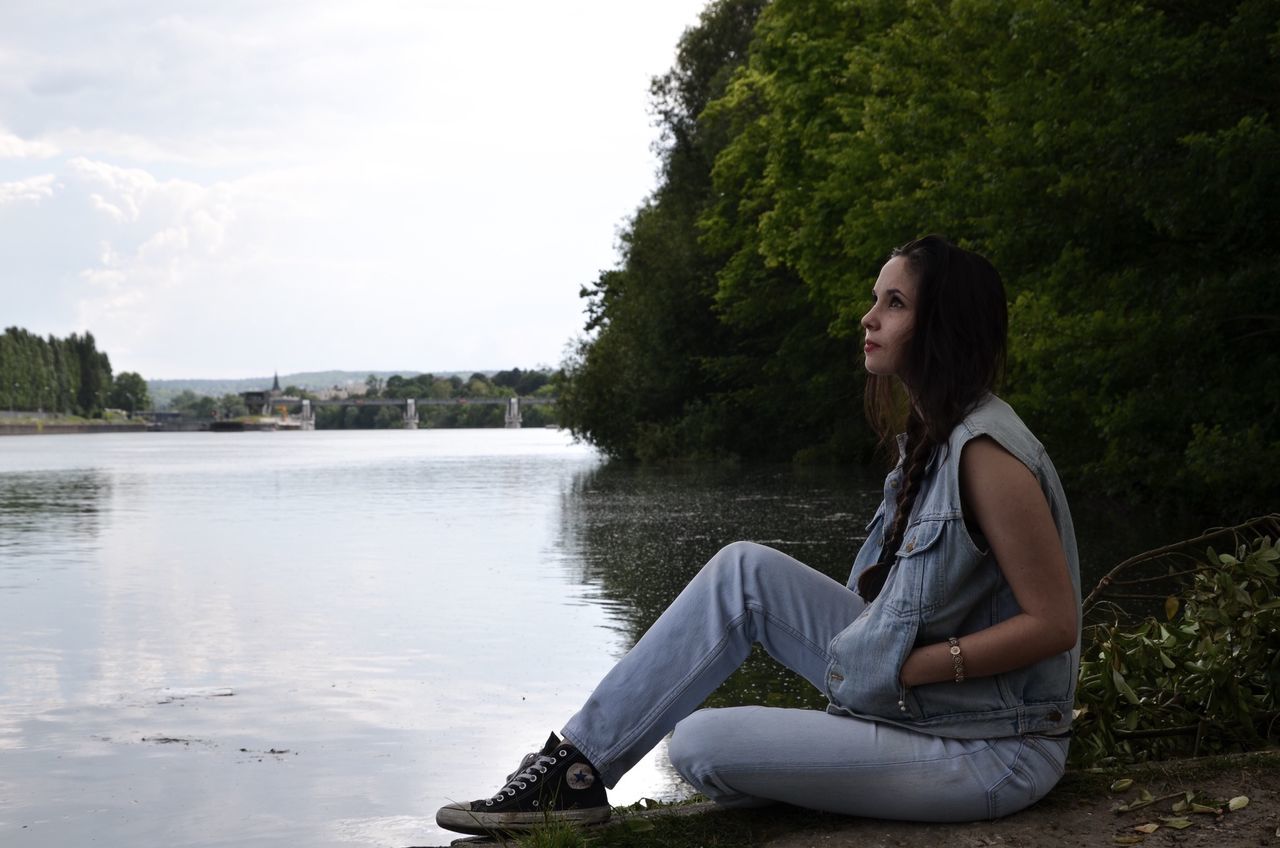 water, young adult, lifestyles, sitting, leisure activity, lake, casual clothing, tree, young women, person, relaxation, river, side view, three quarter length, full length, tranquility, standing, nature