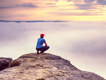 Hiker on sharp cliff of sandstone rock in rock empires park observe misty and foggy spring valley