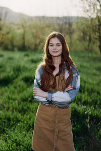 Portrait of young woman standing against plants