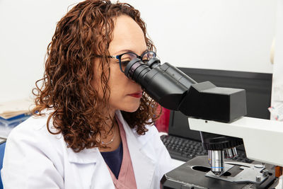 Side view of young woman working in laboratory