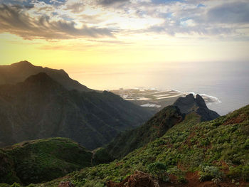 Scenic view of sea and mountains against sky during sunset