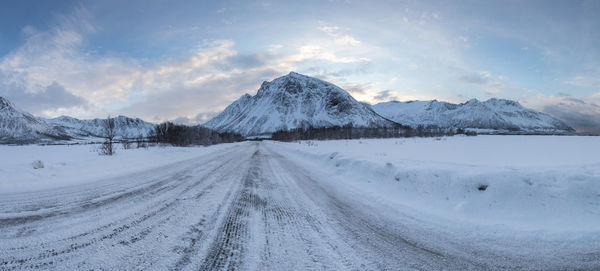 Snow covered landscape with mountain range in background