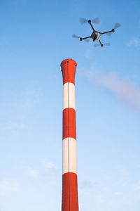 Low angle view of airplane flying against blue sky