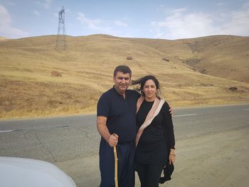 Portrait of mature couple standing on road at desert