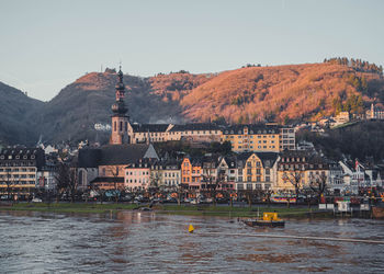 River amidst buildings in city against sky