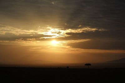 Scenic view of silhouette field against sky during sunset