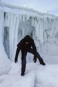 Full length of young woman standing on snow covered