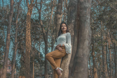 Portrait of smiling young woman in forest