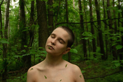 Portrait of shirtless woman in forest