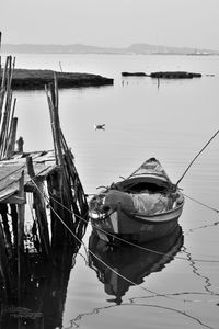 Boats moored at harbor against sky