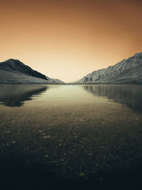 Scenic view of lake against clear sky during sunset