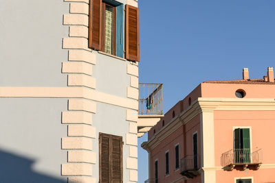 Low angle view of buildings against clear blue sky