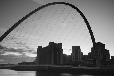 Bridge over river against buildings in city