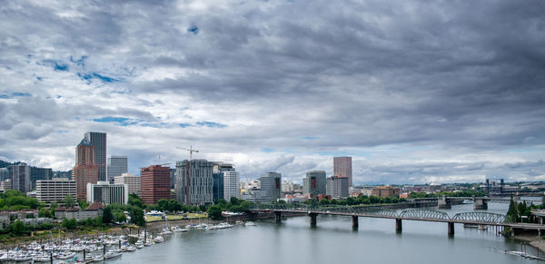 River amidst buildings in city against sky