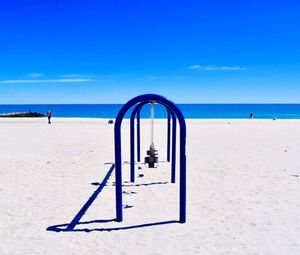 Lifeguard hut on beach against blue sky