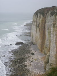 Rock formation on beach against sky