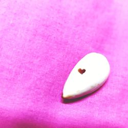 High angle view of heart shape on pink over white background