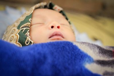 Close-up of baby boy lying on bed