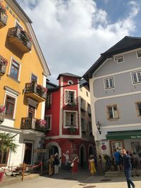 People on houses against sky in city