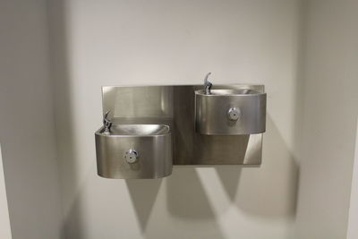 Close-up of drinking fountains on wall