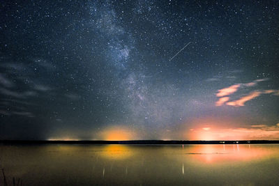 Scenic view of lake against sky at night