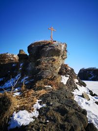 Low angle view of rock formation against clear blue sky