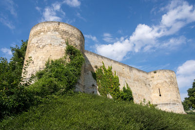 Low angle view of old ruin building against cloudy sky