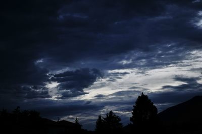 Low angle view of silhouette trees against sky