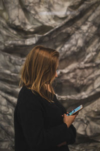 Fashionable young woman in city at night